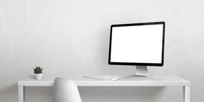 maqueta de pantalla de computadora en el escritorio con espacio de copia al lado de la pared blanca. pantalla de visualización aislada para la promoción de la página web