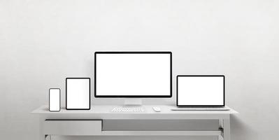 Isolated displays different sizes to promote responsive web pages or apps. Computer display, laptop, tablet and smart phone on work desk photo