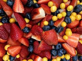 A closeup photo of a fruit salad containing strawberries, blueberries and gooseberries that looks very tastybackground, berries, berry, blue, blueberries, blueberry, breakfast, chopped, closeup, color