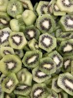 A closeup photo of a fruit salad containing only kiwifruit cut up to display the black seeds and the white center of the light green fruit.