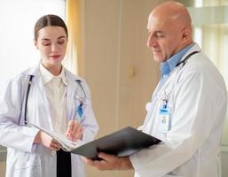 el enfoque selectivo en la doctora se concentra en consultar, discutir con un colega masculino en el hospital. dos especialistas profesionales en atención médica de pie en la clínica haciendo una lluvia de ideas como trabajo en equipo médico. foto