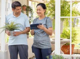 Two middle-aged people planting as hobby, portrait. Smiling couple person happy leisure activity outdoor gardening. Mature husband and wife horticulture have carefree healthy lifestyle growing plant. photo