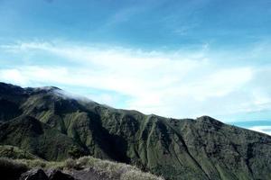 montañas verdes y hermosas nubes de cielo bajo el cielo azul foto