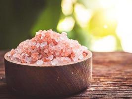 Himalayan salt raw crystals in wood bowl nature background photo