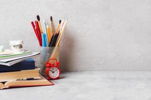 útiles escolares, libros, cuadernos, lápices sobre fondo gris con espacio para copiar. foto