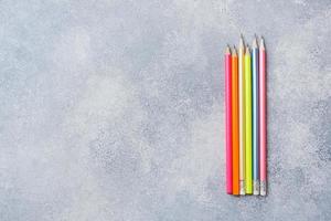 Bright colored pencils on the grey table. concept school. Copy space photo