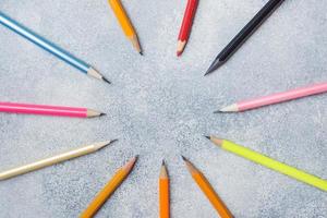 Bright colored pencils on the grey table. concept school. Copy space photo