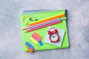 útiles escolares, lápices de cuadernos sobre fondo gris con espacio de copia. foto