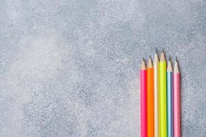 Bright colored pencils on the grey table. concept school. Copy space photo