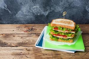 Healthy lunch for school with sandwich, fresh apple. Assorted colorful school supplies. Copy space. photo