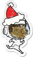 distressed sticker cartoon of a confident astronaut wearing santa hat vector