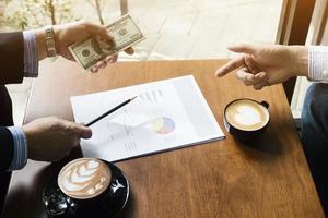 Business man is giving money to a partnership in coffee shop photo