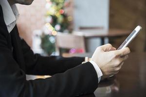 hombre de negocios usando teléfono móvil mientras bebe café en una cafetería - hombre de negocios de estilo de vida moderno en el concepto de cafetería foto