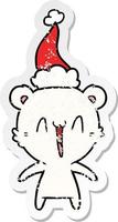 happy polar bear distressed sticker cartoon of a wearing santa hat vector