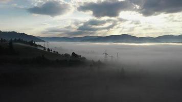 los rayos del sol brillan sobre la niebla, los árboles y las líneas eléctricas en las montañas cárpatas de ucrania video