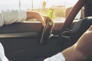 Woman drinking beer while driving a car photo