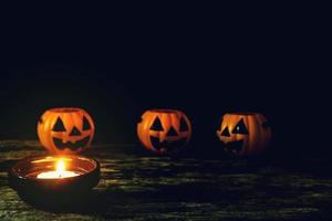 Candles and Halloween pumpkins are placed on wooden floors. photo