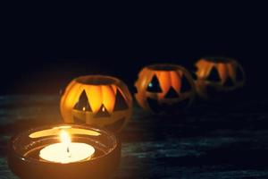 Candles and Halloween pumpkins are placed on wooden floors. photo