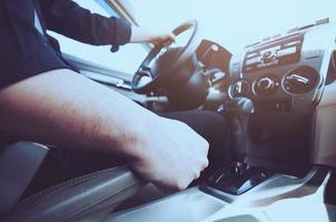 Closeup of man hand pulls car hand brake while driving car - car safe drive concept photo