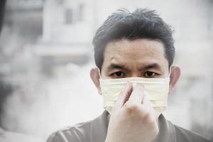 Man wearing mask protect fine dust in air pollution environment - people with protection equipment for air pollution concept photo