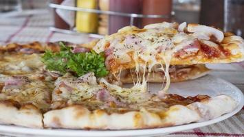 Family lunch eating pizza ham cheese recipe - people with favour italian dish concept photo