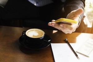 hombre de negocios que trabaja con el móvil en la cafetería foto