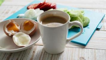 huevos cocidos con ensalada de pepino fresco y juego de desayuno con taza de café - vista superior concepto de comida para el desayuno