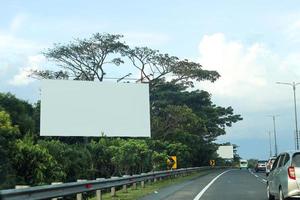 Billboard mockup in highway with traffic atmosphere under beautiful sky. photo