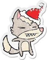 angry wolf distressed sticker cartoon of a wearing santa hat vector