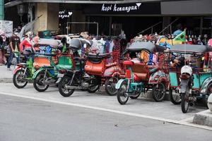 yogyakarta, indonesia - mayo de 2022 fila de rickshaw estacionado en el lado de la carretera de la calle malioboro. becak es un rickshaw o triciclo local, transporte tradicional de indonesia. foto