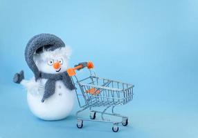 muñeco de nieve con carrito de compras foto