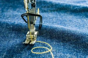 imagen macro de las piezas de la máquina de coser de la siguiente manera aguja y prensatelas en tela de jean foto