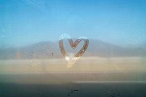 Valentine Concept heart shaped draw by hand on the mirror foggy photo