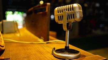 The microphone is located on a wooden table in an old music practice room. photo