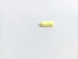 small yellow pills isolated on a white background or on white paper photo