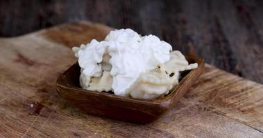 take dumplings with sour cream with a fork during a meal photo