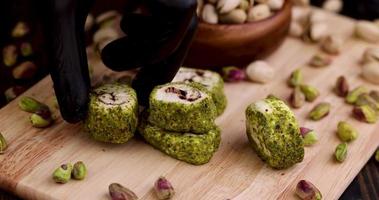 poner delicias turcas frescas con pistachos triturados y chocolate en una tabla foto