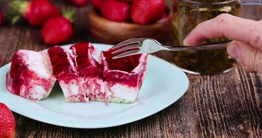 Divide strawberry cake with cheese cream and jam photo