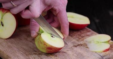 cortar una manzana roja en varios pedazos durante la cocción foto