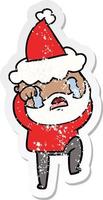 distressed sticker cartoon of a bearded man crying and stamping foot wearing santa hat vector