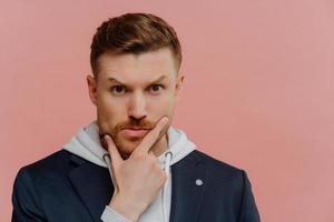 Concerned man holding touching chin and making decision photo