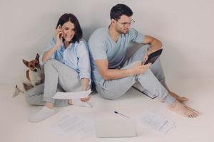 Family budget, payment, finances concept. Family couple analyze documents together, calculate expenses, use calculator, laptop computer, pose on floor, work from home, isolated over white background photo