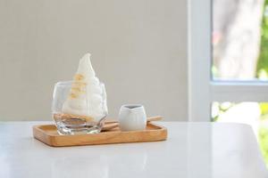 Affogato Espresso on wooden disk on the white table near windows in coffee shop, ice cream, cafe, copy space photo