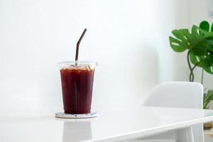 Black coffee, Americano coffee in plastic coffee cup on white table in coffee shop, food, beverage and health concept,copy space photo