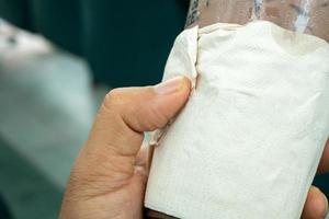 Hand holding a coffee mug wrapped in empty tissue paper,coffee shop, copy space photo