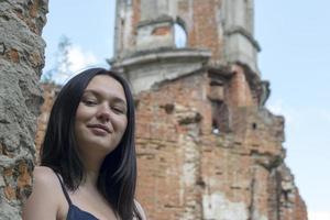 Close up portrait young beautiful woman with ancient ruin. photo