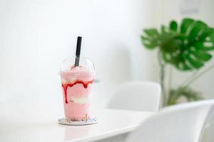 batido de fresa en la taza en la mesa blanca en la cafetería, concepto de comida, bebida y salud, espacio para copiar foto