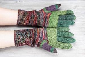palm view of hands in knitted gloves on gray photo