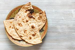 pan plano de trigo integral tandoori roti sobre mesa gris foto