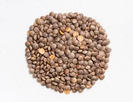 pile of raw brown red lentils close up on gray photo